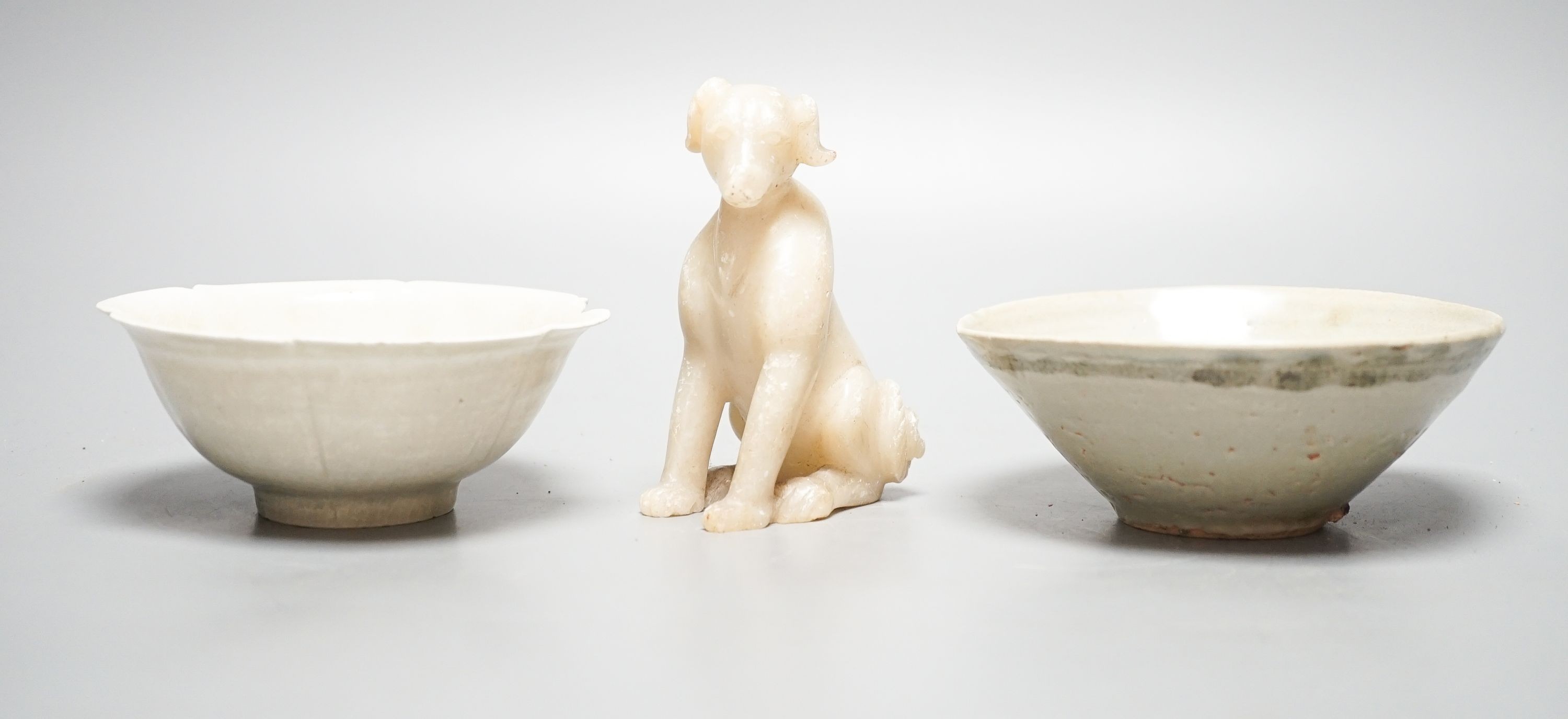 Two Chinese Qingbai bowls, probably Song Dynasty, largest 13, cm and a Chinese soapstone figure of a seated dog, 10.5cm (3)